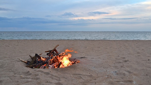 Playa al atardecer con una hoguera para conmemorar la noche de solsticio