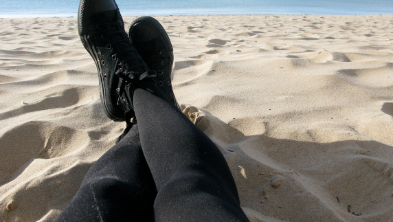 Piernas sobre la arena de la playa en Chiclana